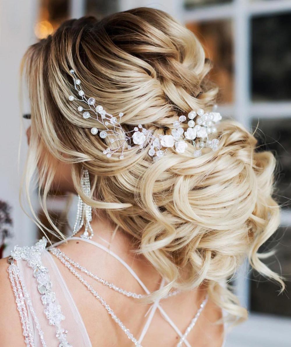 loose low bun wedding hairstyle with accessories