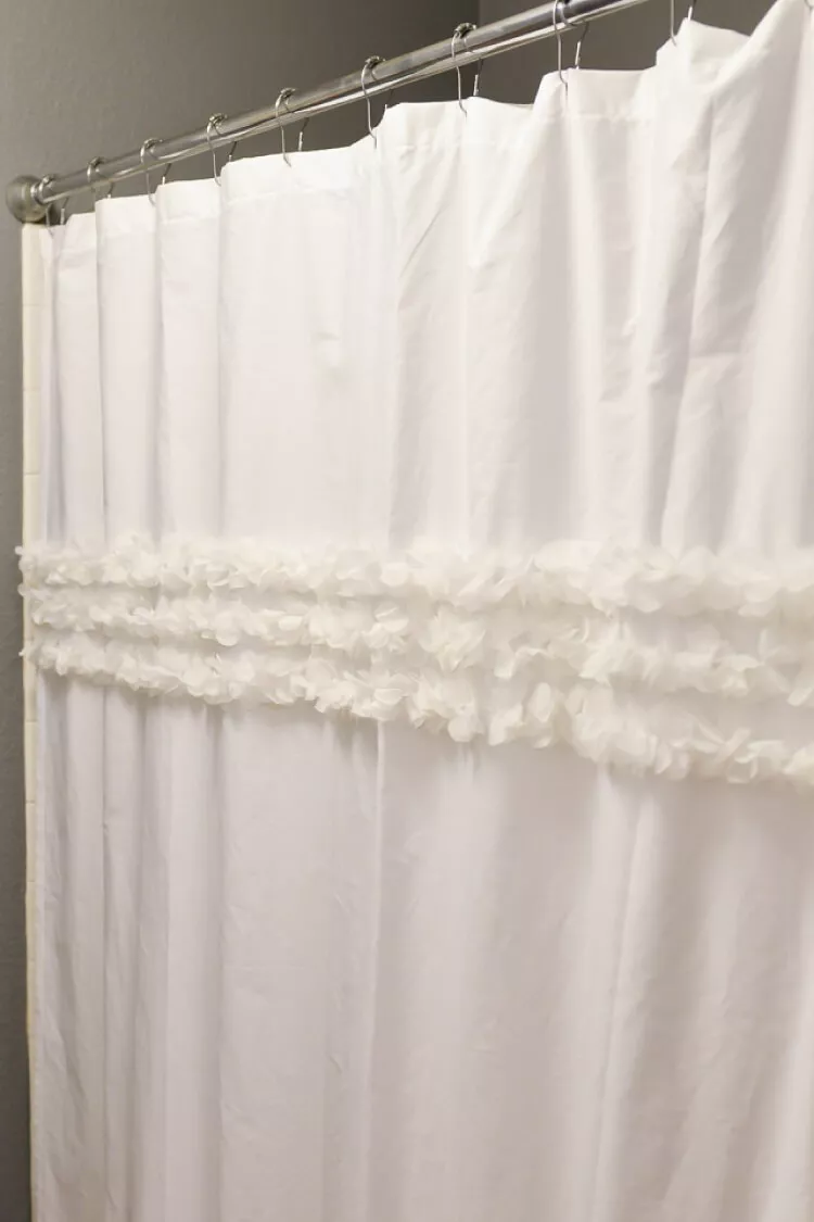 A white DIY shower curtain with floral ruffle