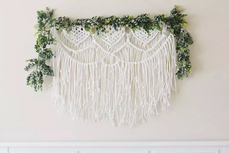 A macrame wall hanging with greenery