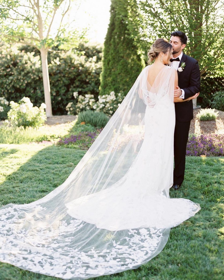 dramatic sheer wedding cape with bride and groom
