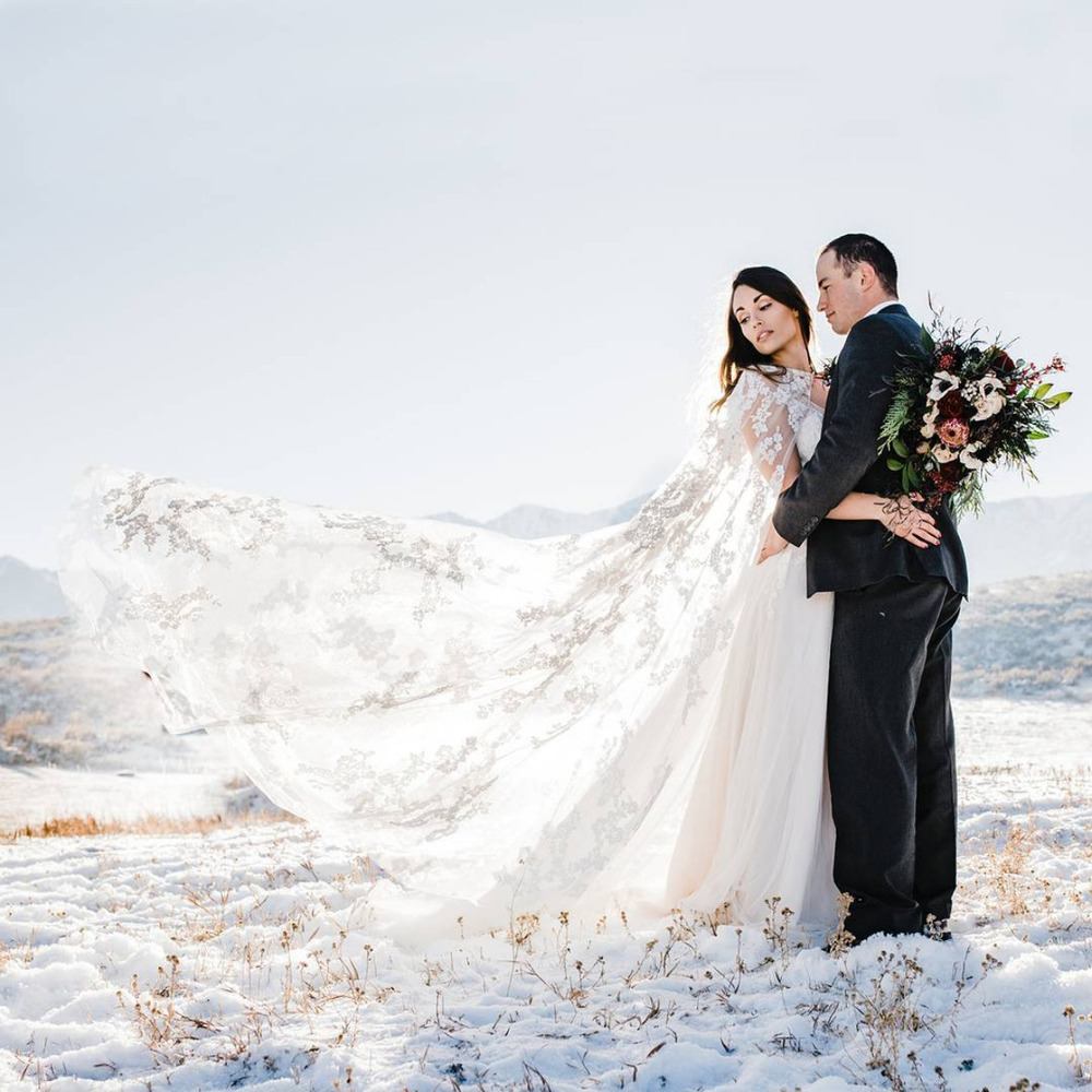 winter wedding bride and groom with lace bridal cape